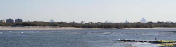 Golden Beach: The Glasshouse Mountains much clearer with less pollution due to lockdowns, as seen from near Golden Beach at Caloundra. Note Bribie Island’s Northern-most tip and sandbar between the buildings and the headland vantage point.