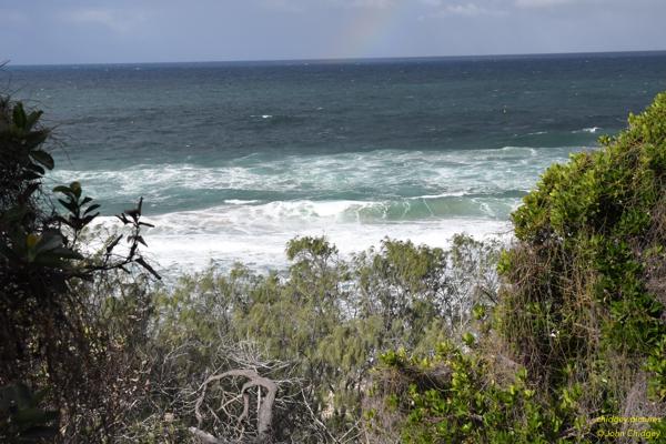 Sunshine Beach Rainbow: On a rainy weekend a while ago, I was walking along a nature walkway between headlands in the Sunshine Beach area, and through a break in the scrub spotted the left hand end of a rainbow over the ocean.